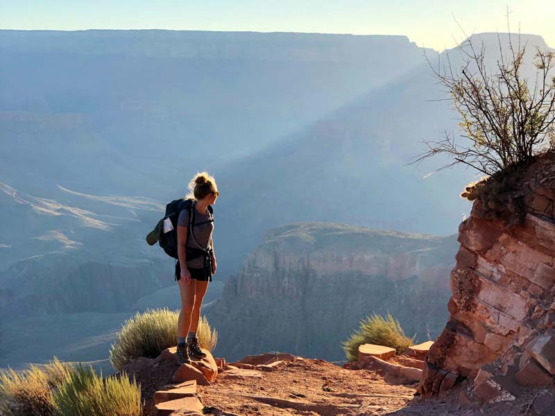 A woman looks out at the ridges of the Grand Canyon.