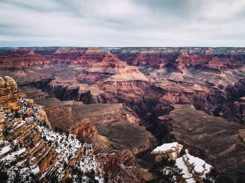 An aerial view of the Grand Canyon, covered by snow in some parts