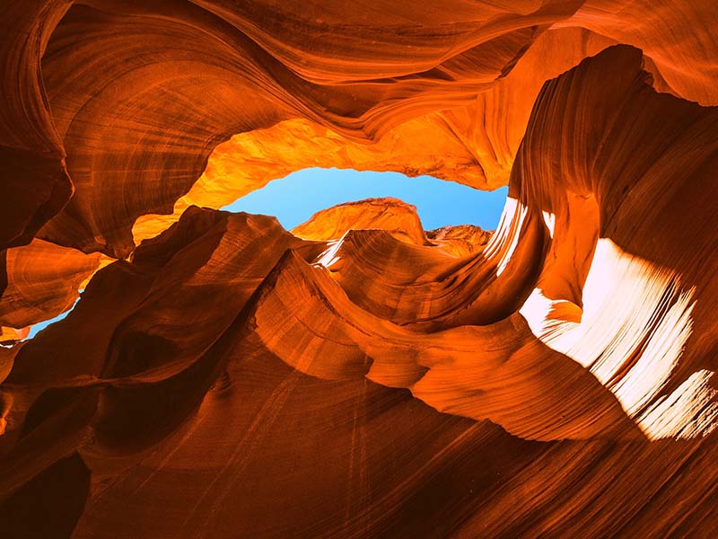 A slit of blue sky, as seen through a a very narrow opening between the walls of the Antelope Canyon