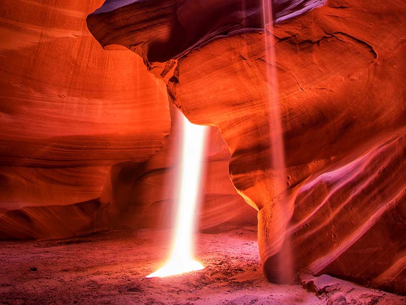 A bright beam of light shining into the Antelope Canyon