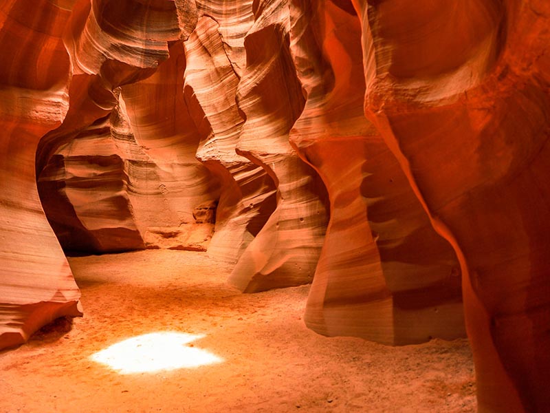 A heart-shaped patch of light on the ground of the Antelope Canyon