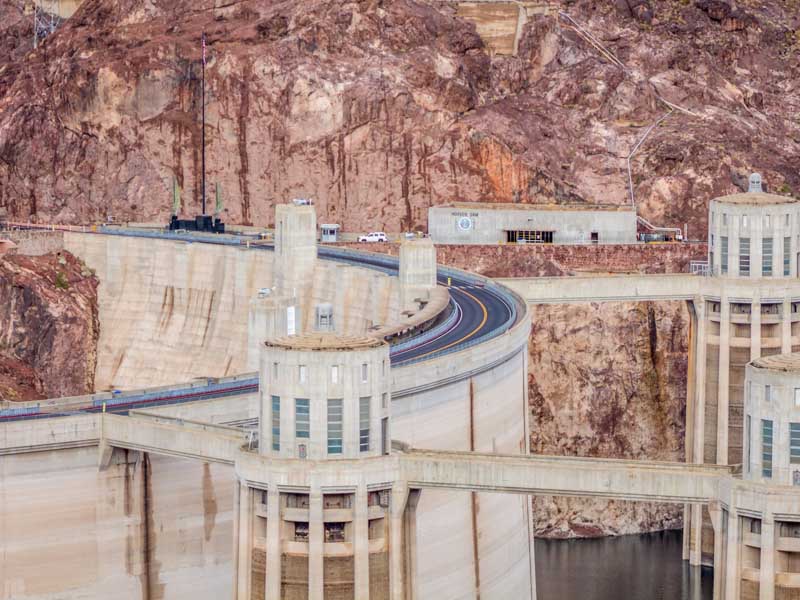 A close view of the Hoover Dam, its structures, and the road on top of it